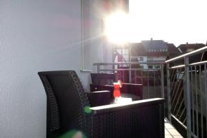 a balcony with two chairs and a candle on a table at HAPPY HOMES - Up to 5 - Küche - W-LAN - Netflix - Honig - Balkon in Nidda