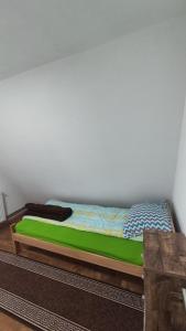 um quarto com uma cama verde num quarto em Vikendica Vrtača- Odvraćenica em Novi Pazar