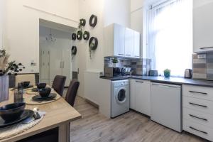 a kitchen with a table and a washing machine at Urban Oasis Apartment in Budapest