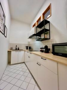 cocina con armarios blancos y microondas en LE Vacation 3-Room-City-Apartment, Küche, Neflix, Free TV, en Leipzig