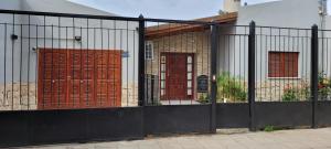 a black fence with two doors in front of a house at Alojamiento marluz in Trelew