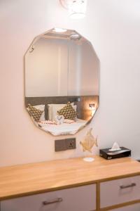 a mirror on a wall above a dresser at Holiday Crib in Dhiffushi
