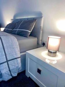 Dormitorio con cama y mesita de noche con lámpara en Large Apartment in City Centre, Leicester, en Leicester