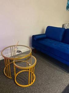 a living room with a blue couch and a glass table at Large Apartment in City Centre, Leicester in Leicester