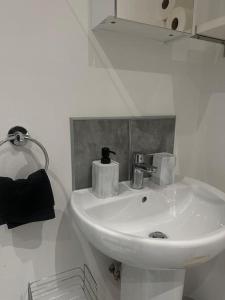 a bathroom with a white sink and a mirror at Large Apartment in City Centre, Leicester in Leicester