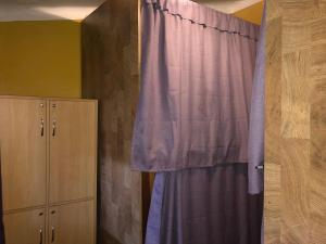 - une chambre avec un rideau violet et une armoire dans l'établissement Intihuatana Hostel, à Pisac
