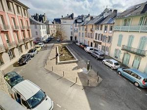 une rue de la ville avec des voitures et des bâtiments en stationnement dans l'établissement [L'ABBAT-JOUR] L'émeraude • Plein Sud • Thermes, à Bagnères-de-Bigorre