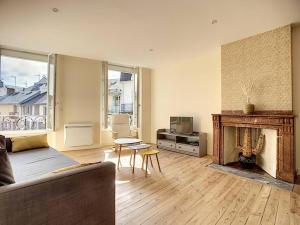 a living room with a couch and a fireplace at [L'ABBAT-JOUR] L'émeraude • Plein Sud • Thermes in Bagnères-de-Bigorre