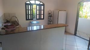 a kitchen with a counter top and a refrigerator at Pousada João e Maria in Trindade