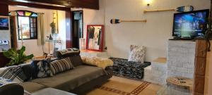 sala de estar con sofá y TV de pantalla plana en Red Rose en Cabo Frío