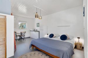 a white bedroom with a bed and a dining room at The Hut Bonaire in Kralendijk