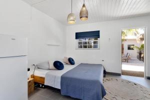 Un dormitorio con una cama con almohadas azules. en The Hut Bonaire en Kralendijk