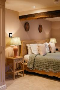 ein Schlafzimmer mit einem Bett und einem Tisch mit einer Lampe in der Unterkunft The Bildeston Crown in Bildeston