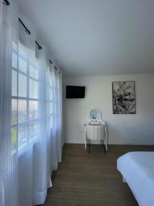 um quarto branco com uma cama e uma janela em Madeiran Sweet Home no Funchal