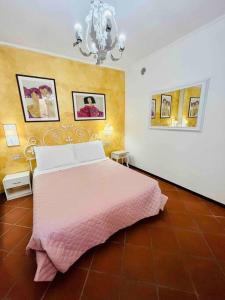 una camera con letto rosa e lampadario pendente di Romantic Apartment on Garda Lake a Desenzano del Garda