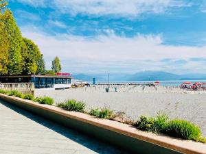 una spiaggia sabbiosa con un edificio e l'oceano di Romantic Apartment on Garda Lake a Desenzano del Garda