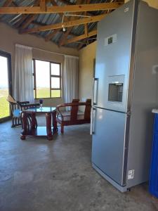 eine große Küche mit einem Kühlschrank und einem Tisch in der Unterkunft Kwa Flats-Emaweni in Lusikisiki