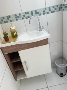 a bathroom with a sink and a toilet at Casa ao lado do centro in Itabira