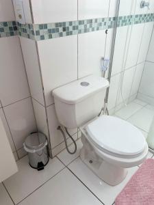 een witte badkamer met toilet en douche bij Casa ao lado do centro in Itabira