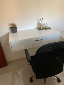 a white desk with a black chair in a room at Casa ao lado do centro in Itabira