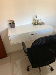 een wit bureau met een zwarte stoel in een kamer bij Casa ao lado do centro in Itabira +11 foto's