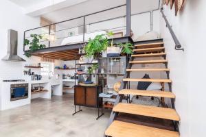 a kitchen with a loft with stairs and plants at The Old Shop Loft apt in the heart of the village in Cape Town