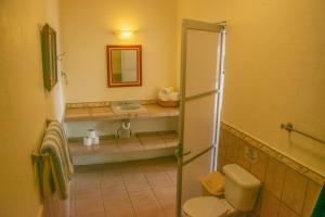 ein Badezimmer mit Waschbecken, Toilette und Spiegel in der Unterkunft La Ventana Beach Resort in La Paz + 32 Fotos