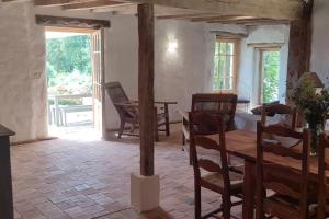 a living room with a wooden table and chairs at Le cottage des Acacias in Salignac Eyvigues