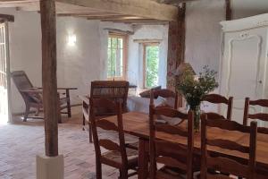 a dining room with a wooden table and chairs at Le cottage des Acacias in Salignac Eyvigues +4 photos
