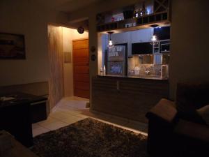 einen Blick auf ein Wohnzimmer mit einer Küche und ein Zimmer mit einem unbeabsichtigten in der Unterkunft Apartamento aconchegante e completo no centro de Ponta Grossa - Paraná in Ponta Grossa