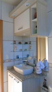 uma casa de banho com um lavatório e uma bancada em Apartamento aconchegante e completo no centro de Ponta Grossa - Paraná em Ponta Grossa