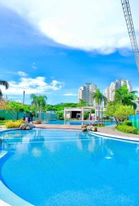 a large blue swimming pool with buildings in the background at Your Crib - kasara -19 D tower 1 in Manila