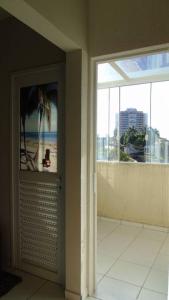um quarto com uma porta com vista para a praia em Apartamento aconchegante e completo no centro de Ponta Grossa - Paraná em Ponta Grossa