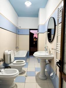 a bathroom with two toilets and a sink and a tub at Villa Malo Guesthouse in Korçë