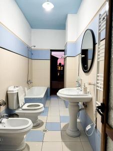 a bathroom with two toilets and a sink and a tub at Villa Malo Guesthouse in Korçë +13 photos