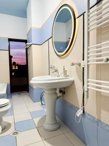 uma casa de banho com um lavatório e um espelho em Villa Malo Guesthouse em Korçë