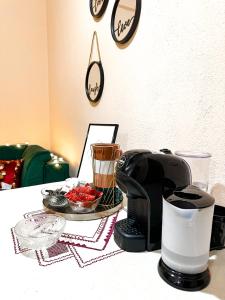 a coffee maker on a table with a plate of fruit at Villa Malo Guesthouse in Korçë
