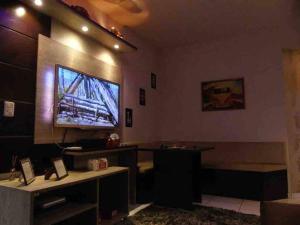 Zimmer mit einem Flachbild-TV an der Wand in der Unterkunft Apartamento aconchegante e completo no centro de Ponta Grossa - Paraná in Ponta Grossa