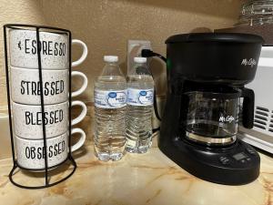 eine Kaffeemaschine und 2 Flaschen Wasser auf der Theke in der Unterkunft Eagle Stay 7 Condo in Eagle Pass