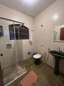 La salle de bains est pourvue d'une douche, de toilettes et d'un lavabo. dans l'établissement Casa na praia, à Bertioga