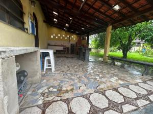 un patio extérieur avec une table et un sol en pierre dans l'établissement Casa na praia, à Bertioga