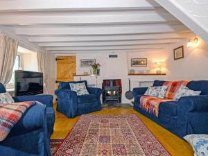 a living room with blue couches and a fireplace at Bridge View Cottage in Middle Mill