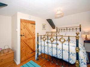 a bedroom with a bed and a wooden door at Bridge View Cottage in Middle Mill