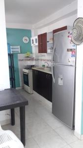a kitchen with a refrigerator and a table in it at Casa Amplia Completa Privada para Familias in Santa Marta