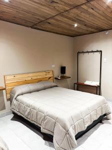a bedroom with a large bed with a board on the wall at Finca German in Vinchina