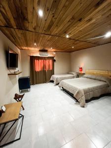 a large room with two beds and a television at Finca German in Vinchina