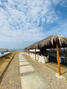 una capanna di paglia sulla spiaggia vicino all'oceano di Zorritos Backpakers a Tumbes