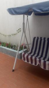 a beach chair under an umbrella on a patio at Casa Amplia Completa Privada para Familias in Santa Marta