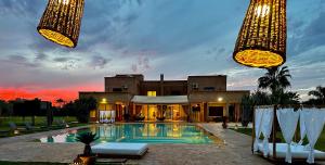 a villa with a swimming pool at dusk at L'Orientale By La Siredrah in Marrakech