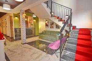 ein Wohnzimmer mit einer Treppe und einer grünen Couch in der Unterkunft Residence Spa Apartments DUB in Kotor